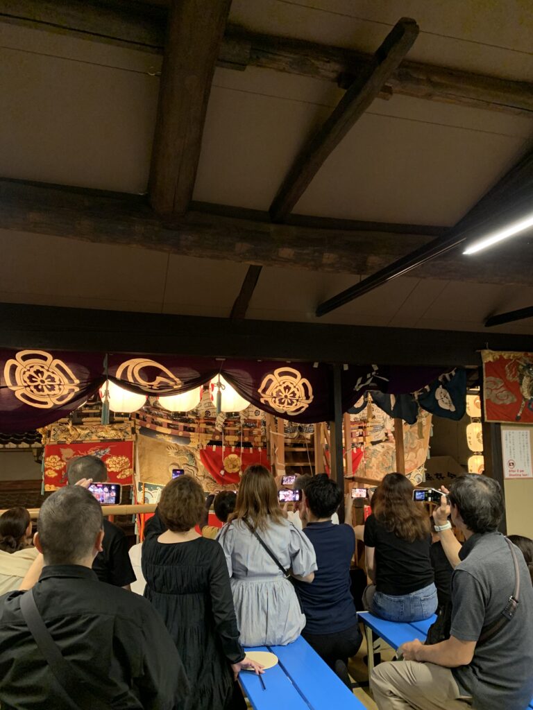 祇園祭の船鉾内部から装飾や木組みを見学する人々