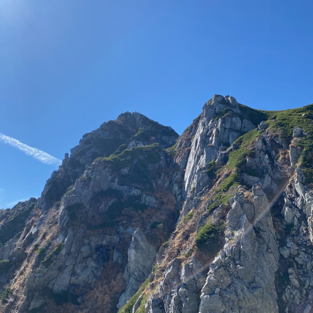 青空の下にそびえる中央アルプス宝剣岳周辺の険しい岩峰