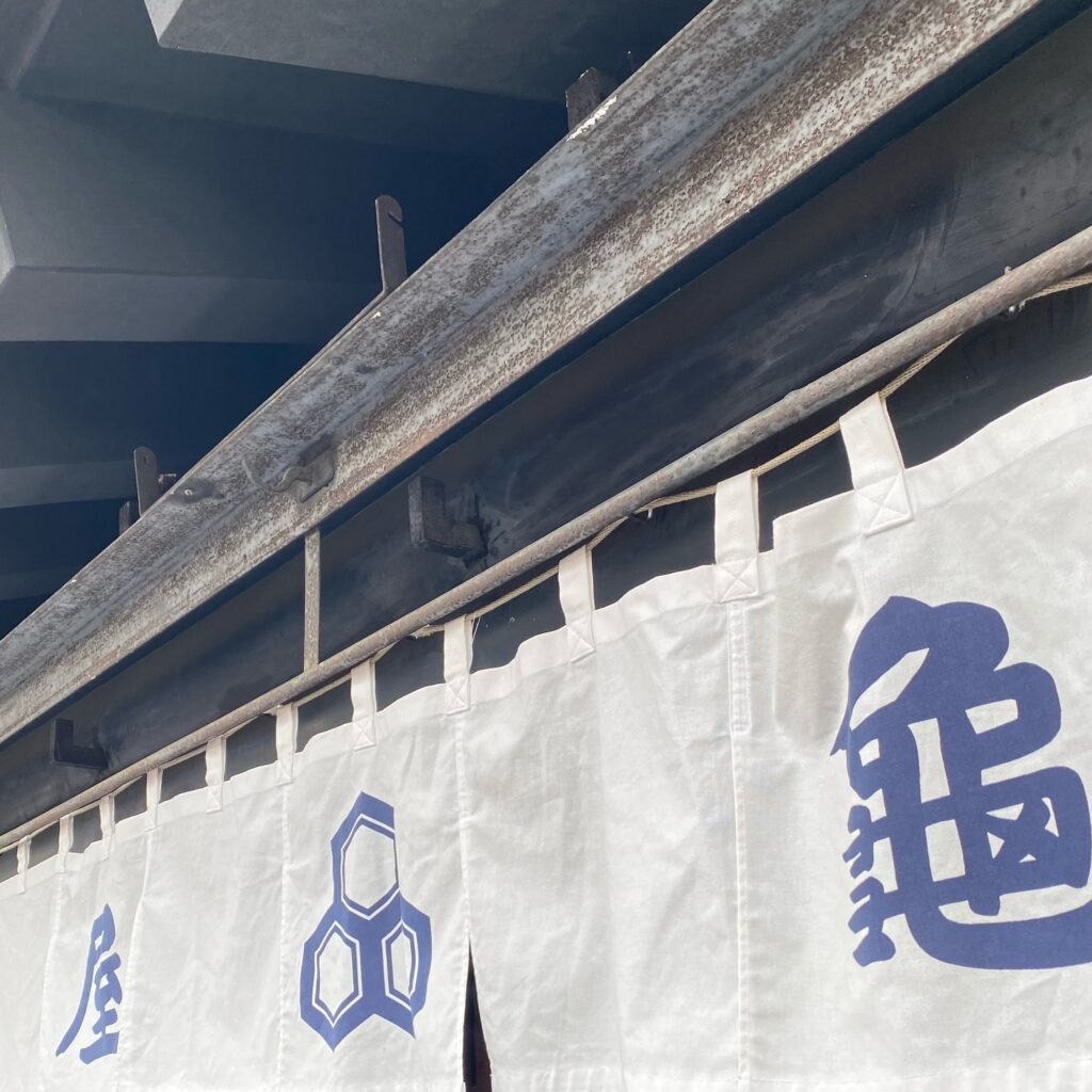 老舗和菓子店・亀屋の屋号と紋が染められた暖簾