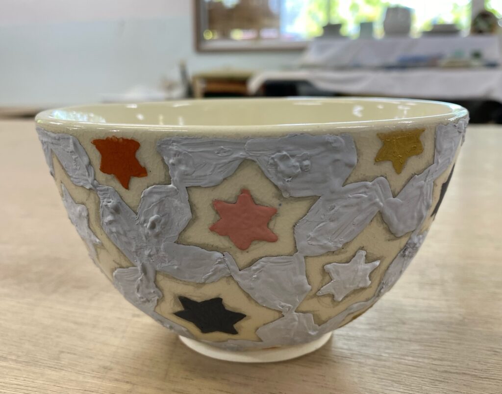 尾形乾山に学んだ色絵茶碗の制作作品。灰色の面と星形の文様を組み合わせた抽象的な構成。