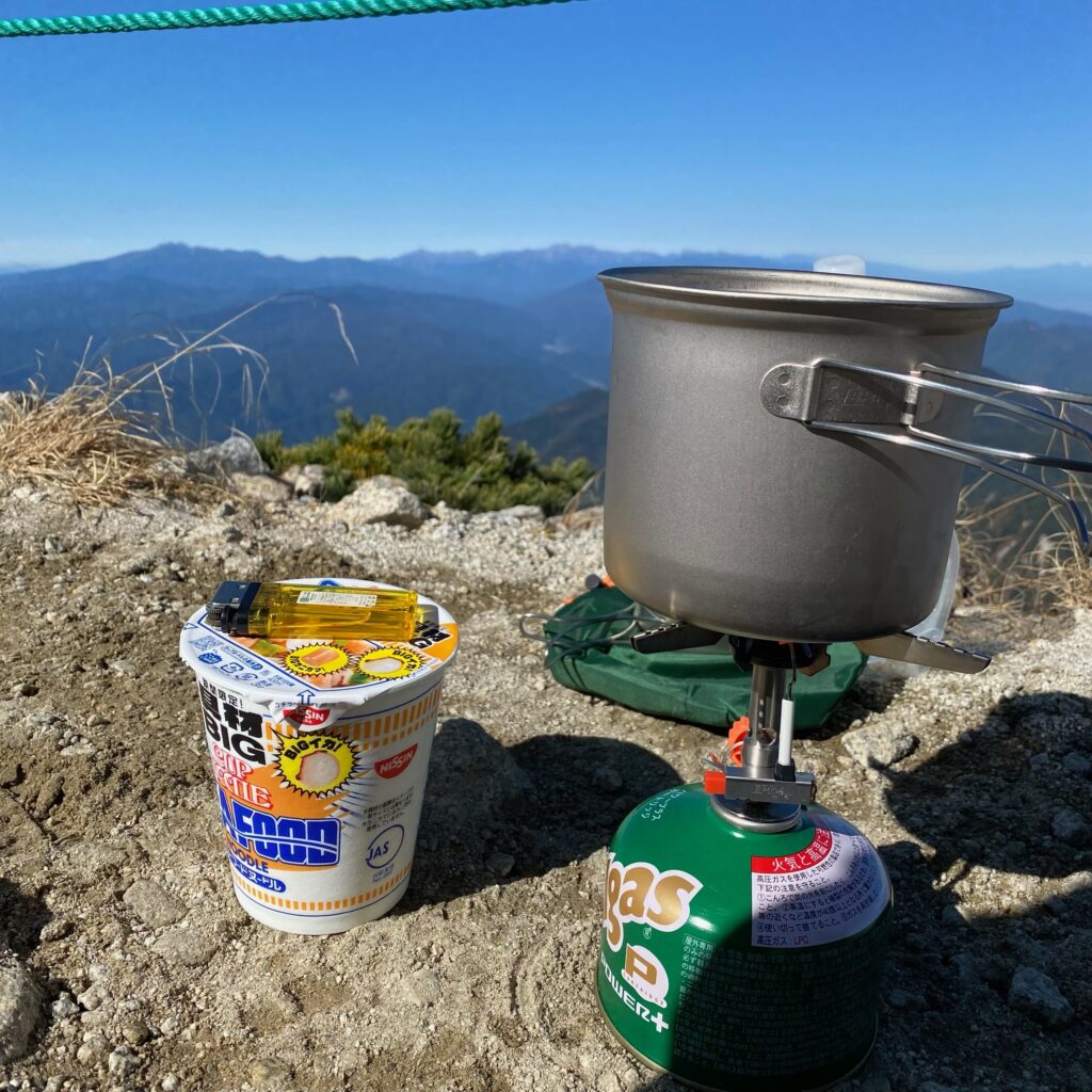 木曽駒ヶ岳の山上でバーナーと鍋を使いカップヌードルを作る様子