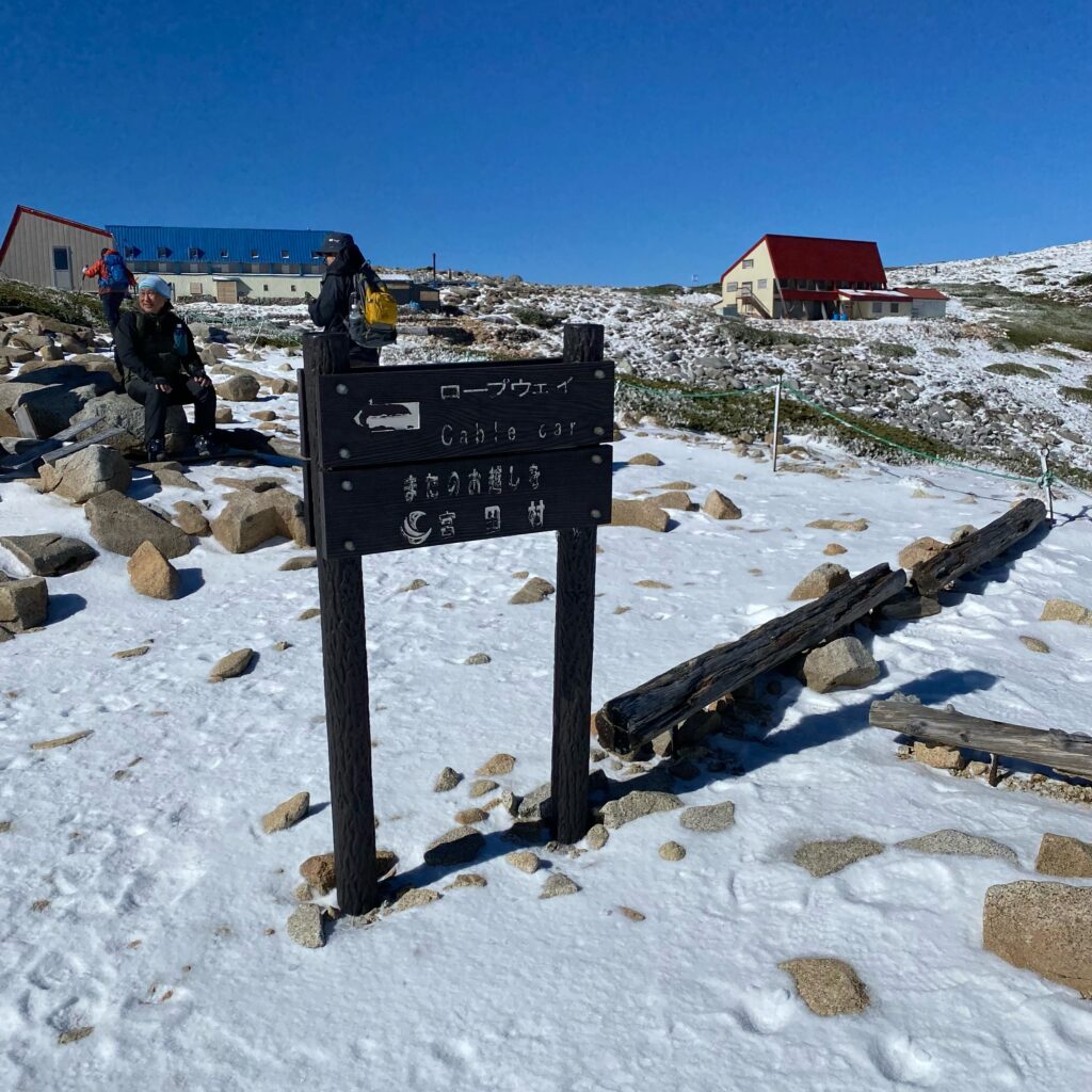 雪が積もった木曽駒ヶ岳の登山道と山小屋、ロープウェイ方面の道標