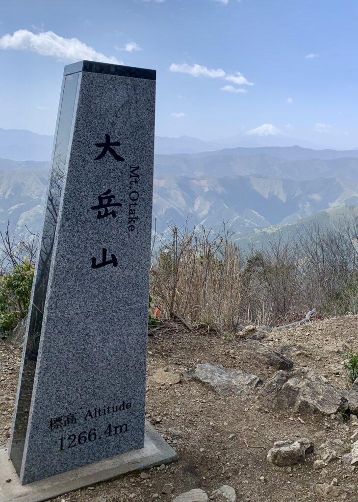大岳山山頂の標識と遠くに見える富士山