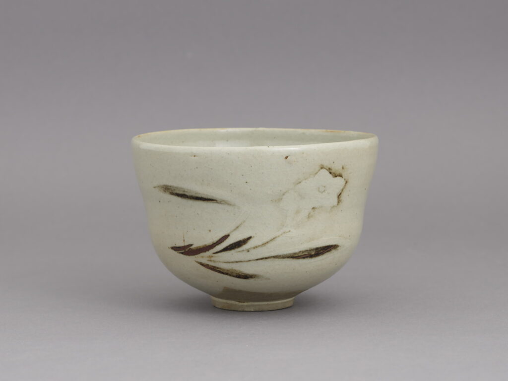 白い器肌に水仙をレリーフ状に表した野々村仁清の銹絵茶碗
