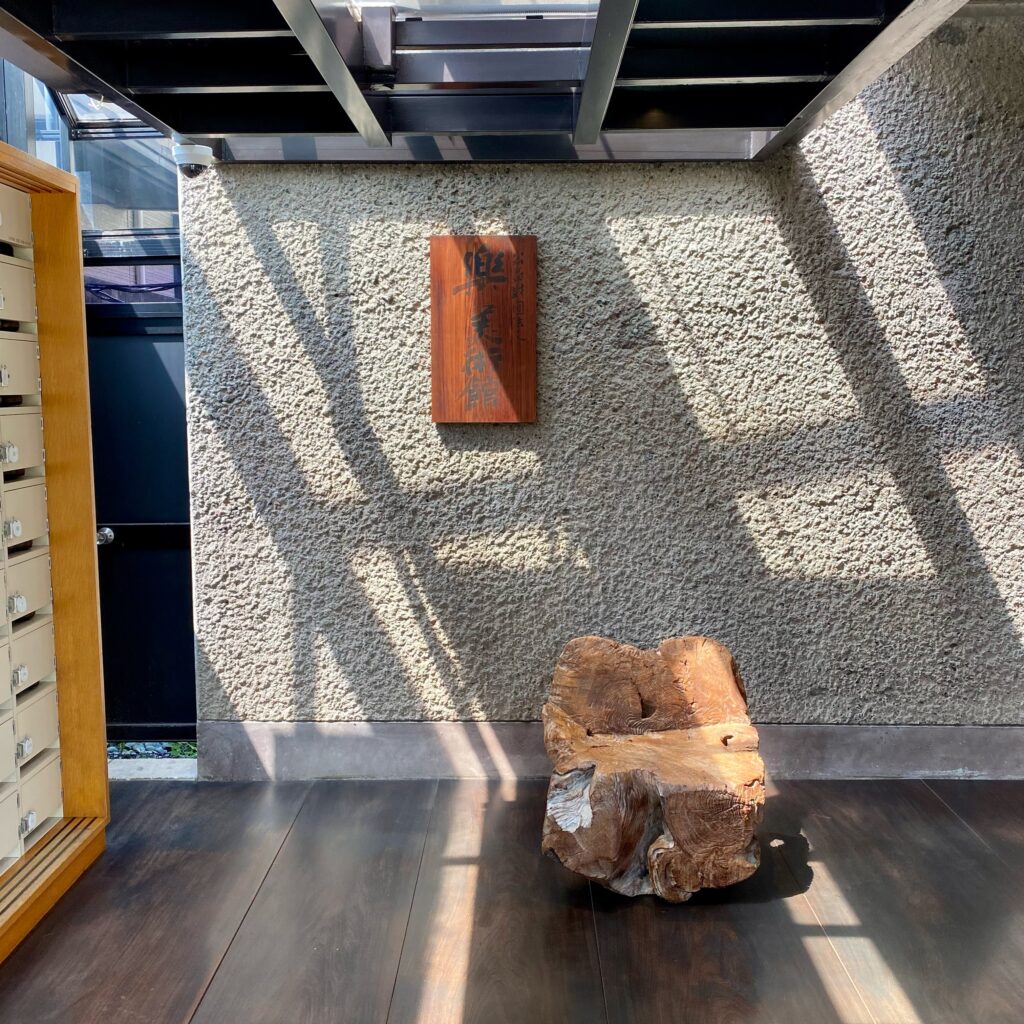 樂美術館入口付近の館内と木製ベンチ