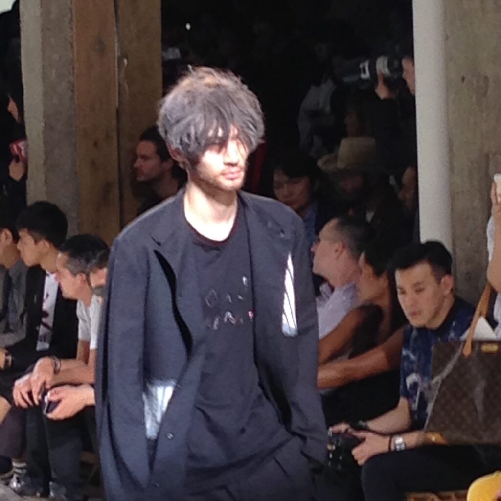 黒のゆったりしたジャケットとパンツを着たモデルの写真