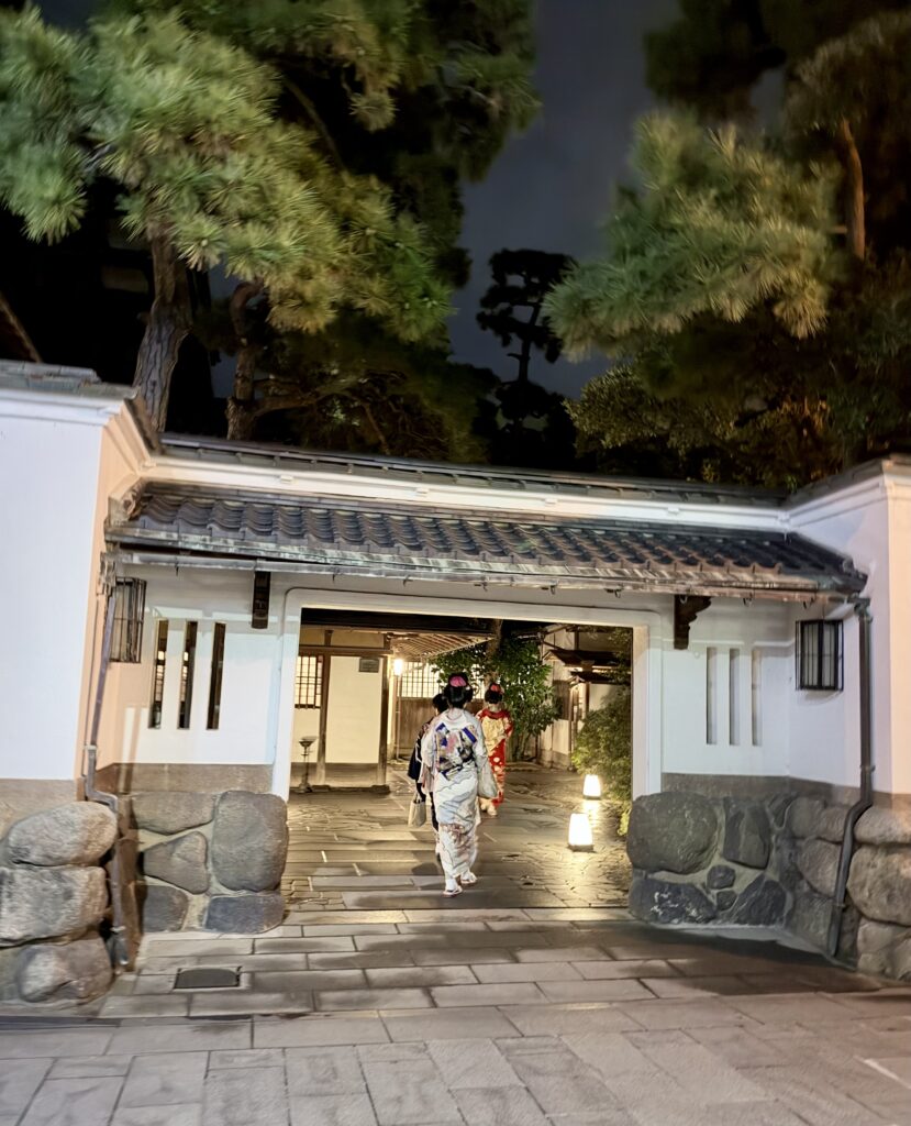 夜の鍋茶屋の門をくぐる着物姿の古町芸妓