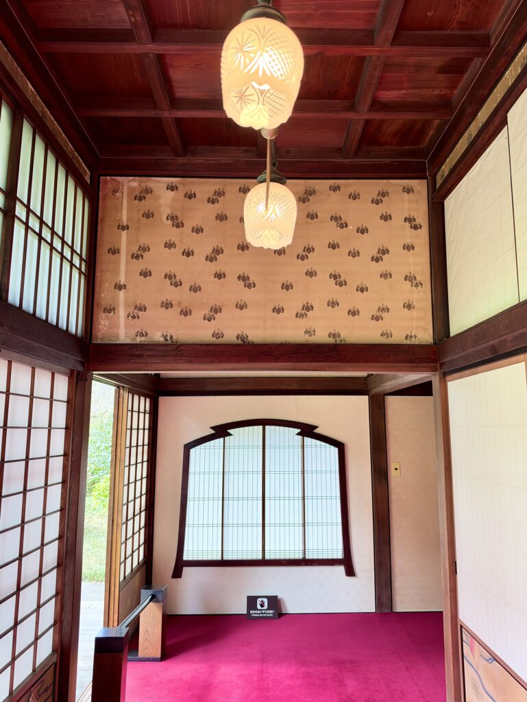 三井八郎右衞門邸の赤い絨毯と装飾照明の廊下