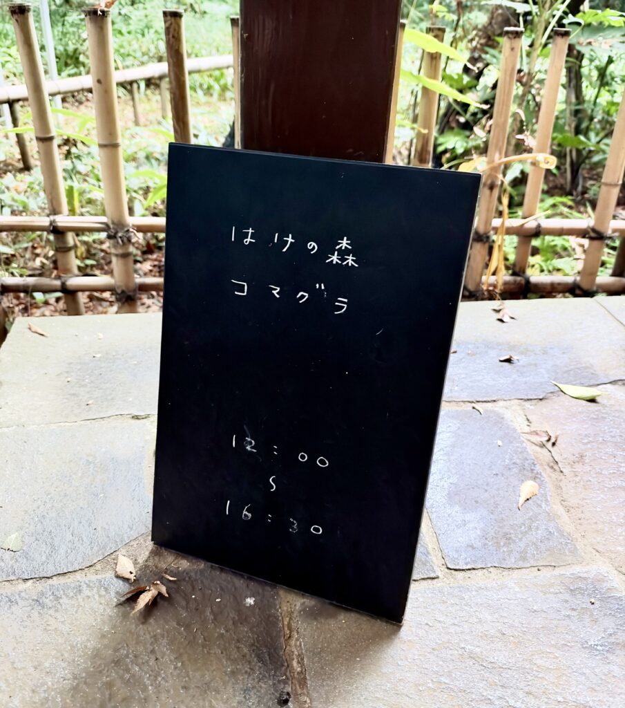 「はけの森 コマグラ」と書かれた黒い案内板