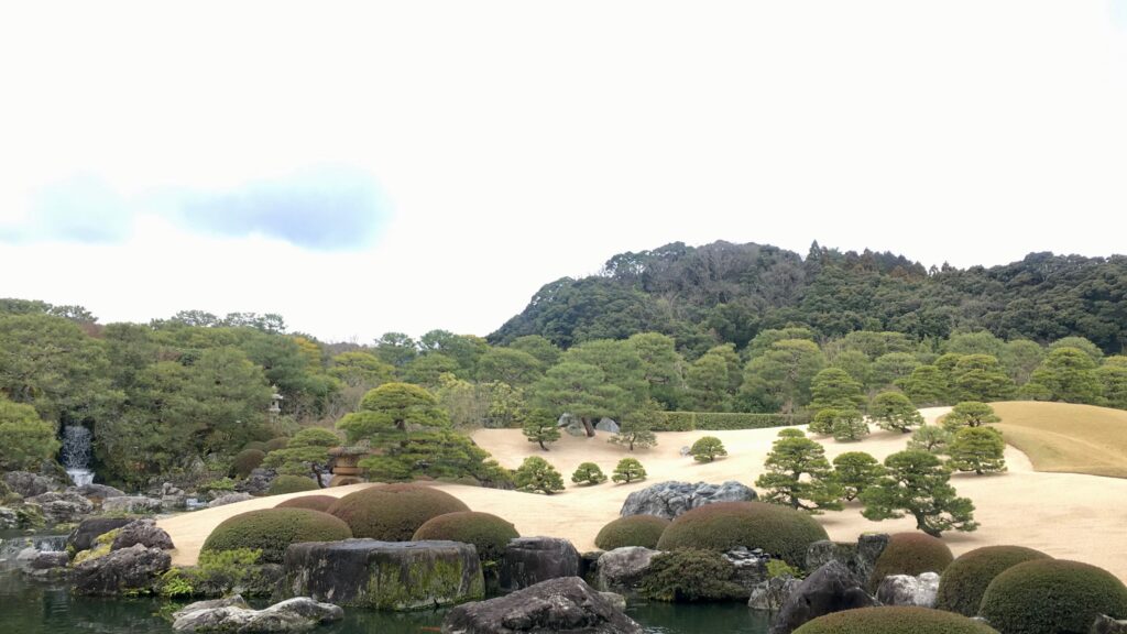 足立美術館の白砂庭園と松、自然石、背後の山並み