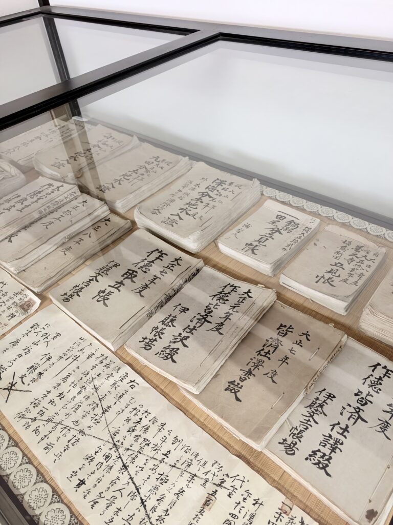 ガラスケース内に多数並べられた伊藤家の古い帳簿や文書