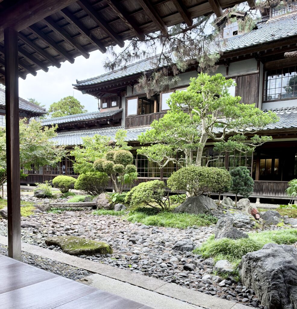 石を敷いた枯流れの庭越しに見る北方文化博物館の伊藤家旧邸